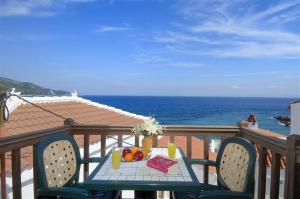 a table with fruit on a balcony with the ocean at Achinos Apartments and Maisonettes in Kokkari
