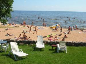 people on a beach with chairs and people in the water at Hostel Laguun in Kallaste