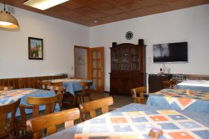 a restaurant with tables and chairs and a flat screen tv at Pension "Zum Schwan" in Muhr amSee