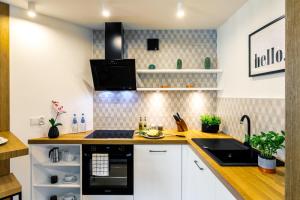 a kitchen with white cabinets and a black stove at Rent like home - Droga na Bystre in Zakopane
