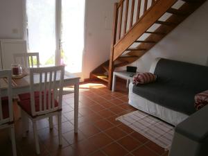 a living room with a couch and a table and stairs at La Chenillette in Carsac-Aillac