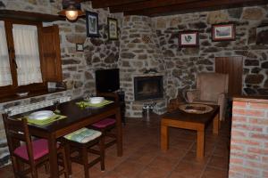 ein Wohnzimmer mit einem Tisch, Stühlen und einem Kamin in der Unterkunft La Seronda de Redes in Bueres