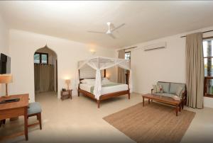 - une chambre avec un lit, un canapé et une table dans l'établissement Kisiwa on the Beach, à Paje