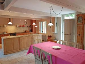 uma cozinha com uma mesa com uma toalha de mesa rosa em Beautiful villa with pool in Mormoiron em Mormoiron