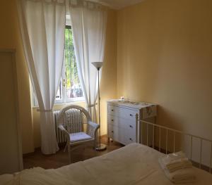 - une chambre avec un lit, une commode et une fenêtre dans l'établissement 3 Via Guglielmo Koerner Apartment, à Milan