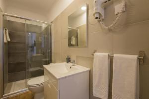a bathroom with a toilet and a sink and a shower at Mar- Milfontes Rentals in Vila Nova de Milfontes +51 photos
