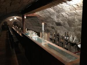 a bar in a cave with a stone wall at Óvár 12 Vendégház in Tokaj