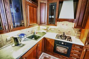 a kitchen with wooden cabinets and a stove top oven at Miracle Apartments on Smolensky Boulevard in Moscow