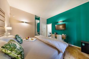 a bedroom with a large bed and a green wall at Album Boutique Rooms in Sassari