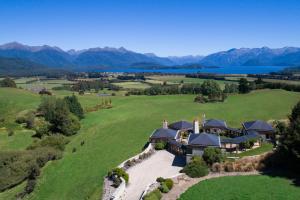 an aerial view of a house on a green field at Cabot Lodge - Fiordland National Park in Manapouri