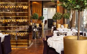 a restaurant with white tables and chairs and wine bottles at Jõe Apartments - apartments with sauna in the city center in Tallinn