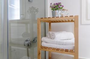 - une pile de serviettes sur une étagère en bois à côté d'une douche dans l'établissement Empuriabrava Apartaments No 5, à Empuriabrava