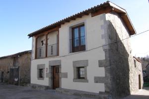 a white building with windows and a door at Casa Rural El Zahorí De Pinedas in Pinedas