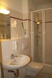 a bathroom with a sink and a toilet and a shower at Hotel am Rugard in Bergen auf Rügen