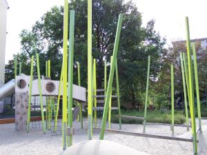 un parque infantil con postes verdes y amarillos en 3 Bedroom Apartment (ACELI) en Berlín