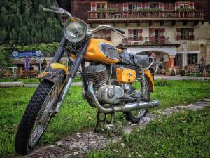 una moto naranja estacionada frente a una casa en Hotel Schlosswirt en Großkirchheim