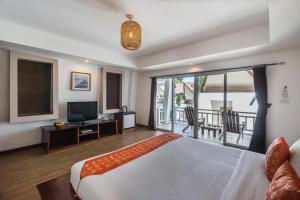 a bedroom with a large bed and a balcony at Cocohut Beach Resort Koh Phangan in Haad Rin