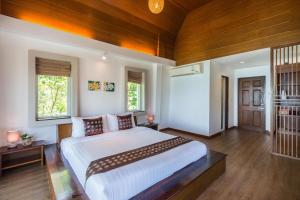 a bedroom with a large white bed in a room at Cocohut Beach Resort Koh Phangan in Haad Rin
