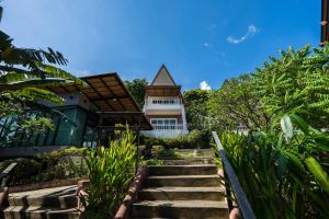 a building with stairs in front of a house at Cocohut Beach Resort Koh Phangan in Haad Rin