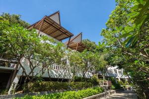 a building with trees in front of it at Cocohut Beach Resort Koh Phangan in Haad Rin
