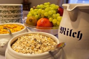 a table topped with bowls of food and fruit at Hotel Garni Wenglhof in Sankt Gilgen