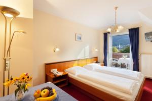 a bedroom with a bed and a table with a bowl of fruit at Hotel Garni Wenglhof in Sankt Gilgen