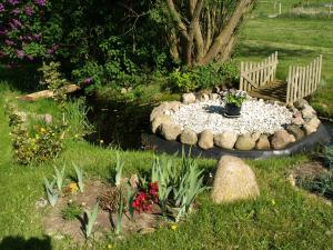 einen Garten mit einer Bank und ein paar Blumen und einem Teich in der Unterkunft Landhaus Kranichwiese in Göhren-Lebbin