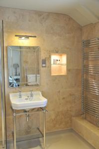 uma casa de banho com um lavatório e um espelho em The Red Lion Inn em Babcary