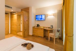 a bedroom with a television and a bed at Hotel Ambassador in Levico Terme