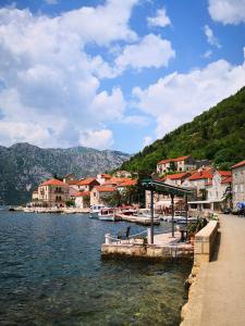 a town on the water with houses and boats at Marina House in Perast