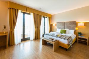 a bedroom with a large bed and a large window at Hotel Ambassador in Levico Terme
