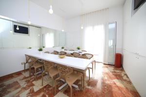 a dining room with a large white table and chairs at Quilungomare in Porto Cesareo