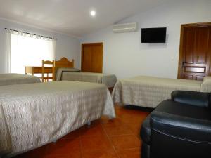 
a hotel room with two beds and a desk at Hostal San Miguel in Trujillo
