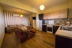 a kitchen and living room with a table and a couch at Regina apartments Simotata Sissia in Lourdata