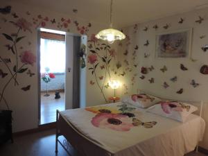 sypialnia z łóżkiem z motylami na ścianie w obiekcie Chez Papy et Mamy w mieście Saint-Chef