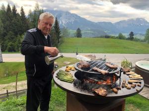 Um homem está a cozinhar comida numa grelha. em Ferienhaus Stoiser em Pruggern mais 50 fotografias