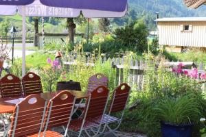 Hotel Schlosswirt في غروسكرتشاين: طاولة وكراسي في حديقة بها زهور