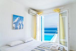 a bedroom with a bed and a view of the ocean at Villa Boufla in Agios Ioannis Mykonos