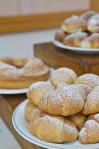 een stapel donuts in poedervorm op borden op tafel bij Albergo Les Dependances in Norcia
