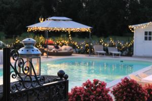 a swimming pool with lights and a lantern at Villa Belvedere 1849 in Misano di Gera dʼAdda