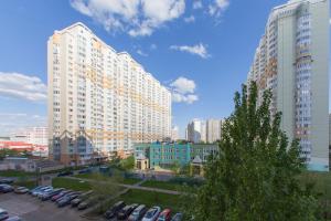 モスクワにあるApartment Coralの高い建物と車が駐車場にある都市