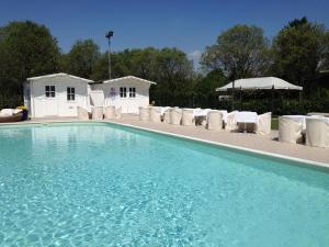 a swimming pool with chairs and a group of buildings at Villa Belvedere 1849 in Misano di Gera dʼAdda