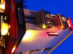 a building with a sign on the side of it at night at Café Hôtel de l'Avenir in Saint-Ouen