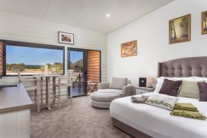 a bedroom with a bed and a kitchen with a balcony at The Swan Valley Retreat in Henley Brook