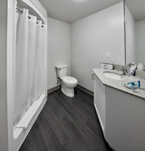 biała łazienka z toaletą i umywalką w obiekcie Residence & Conference Centre - King City w mieście King City