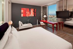 a hotel room with a bed and a desk with a view at Melia Barcelona Sky 4* Sup in Barcelona +125 photos
