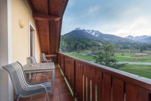 a balcony with a table and chairs and a view at Villa Planina in Kranjska Gora