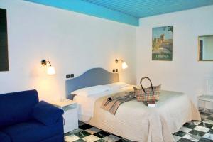 a bedroom with a bed and a blue couch at Hotel Raffaello - Self Check-in Free in Urbino