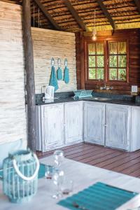 a kitchen with white cabinets and a table in a room at Paradise Dunes in Praia do Tofo