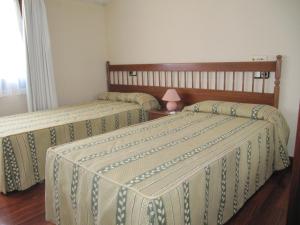 a bedroom with two beds with green and white sheets at Casa Pardo in Gibaja